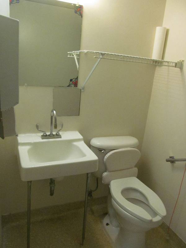 lot 113 image: (Rm 41) Bathroom-toilet, sink, dispenser, wire shelf, mirror