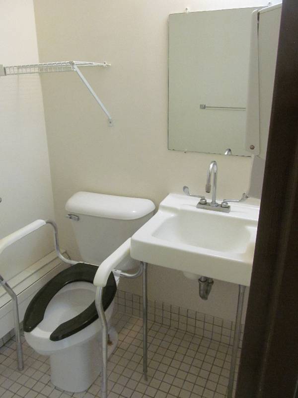 lot 131 image: (Rm 38) Bathroom, toilet, sink, wire rack, soap, towel dispensers
