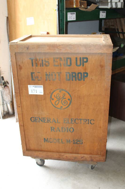 lot 171 image: Vintage Rolling Wood Crate. labeled that it used to house a GE upright radio M-125 which was from the 30s