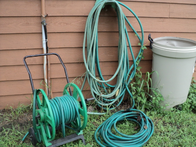 lot 73 image: Several garden hoses and hose reel,...
