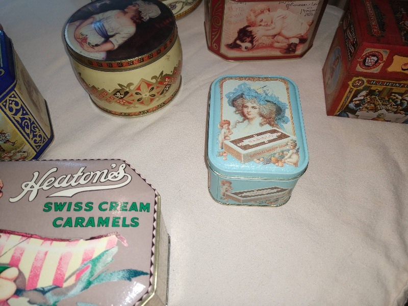 lot 81 image: Vintage Poppy Highly Perfumed Talcum Powder Tin, Bessie Pease Gutmann In Disgrace Tin, J&ampP Coats Six Cord Thread Tin, Heatons Swiss Cream Caramels Tin, Girl in Bonnet Tin, Hoyts German Cologne Tin, H.J. Heinz Company Recipes Tin