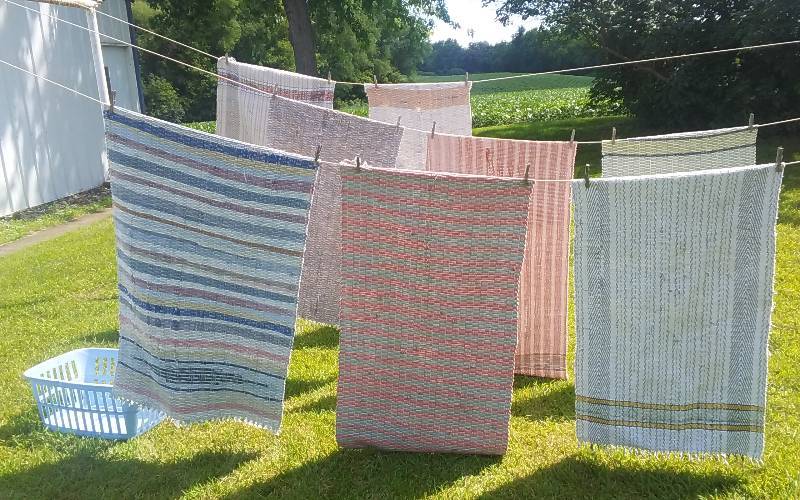 lot 63 image: Laundry Hamper & Assorted Rag Rugs