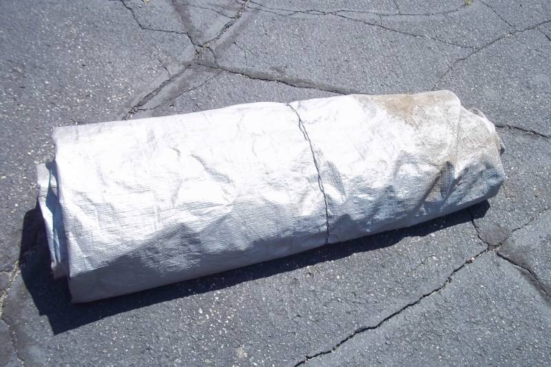 lot 25 image: Silver Tarp. May Have holes. Great For Wood Pile