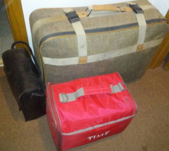 Suitcase, duffel, and pouch with dozens more bags inside