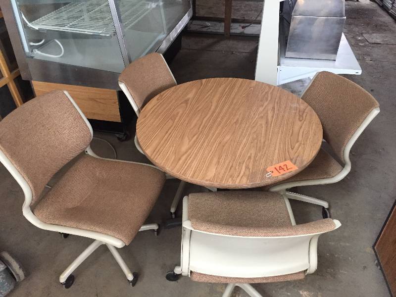 lot 142 image: 36 round Nutmeg table with matching Steelcase chairs