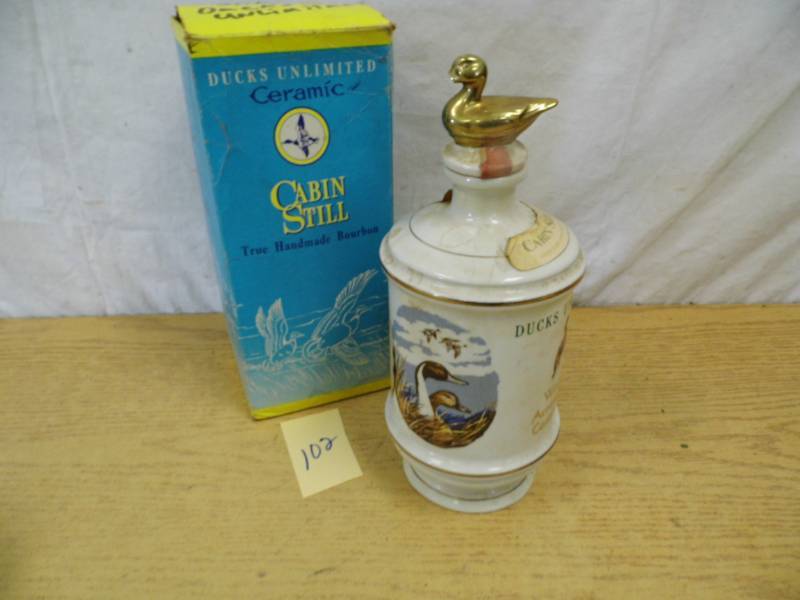 lot 102 image: Cabin Still Ducks Unlimited Bottle