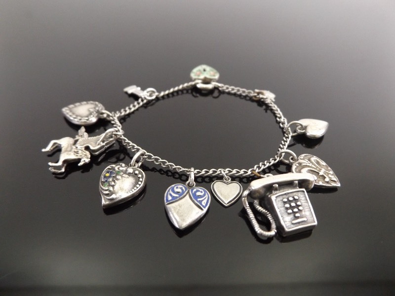 lot 7 image: Vintage .925 Sterling Silver 11 Charm Bracelet
