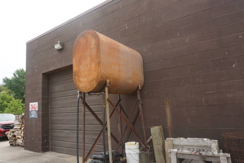 lot 23 image: 250 Gallon Fluid Storage Tank With Metal Stand, Concrete Base and Discharge Hose and Nozzle