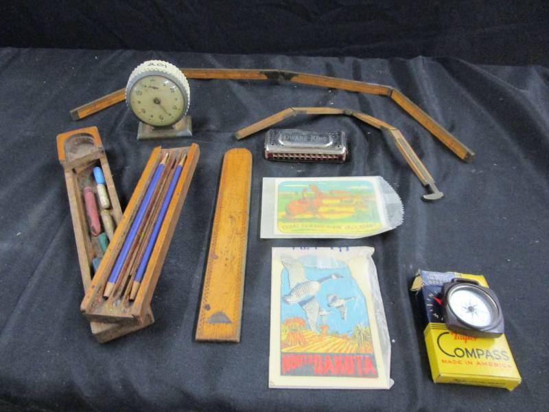 lot 75 image: Antique tape measures, drafting items, compass, harmonica, and old clock
