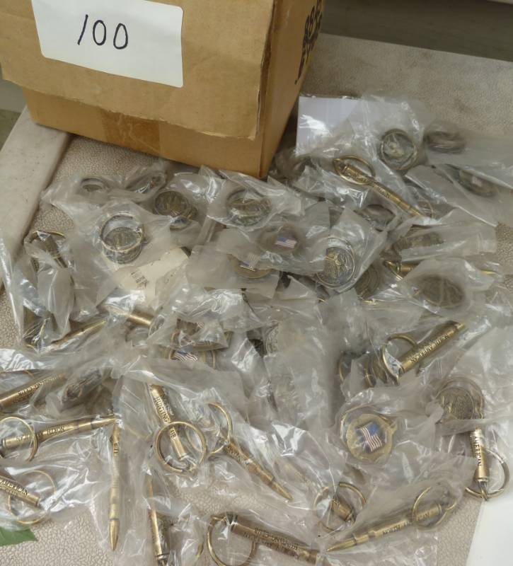 lot 100 image: 80 keychains, bullet shaped and North american hunting club with flag