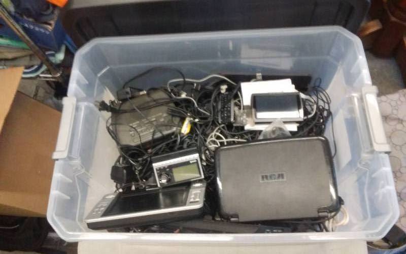 lot 23 image: Tote With Lid Portable DVD Players, Harmon Carden GPS, Sirius Satellite Radio, Large Assortment Of Power Cords