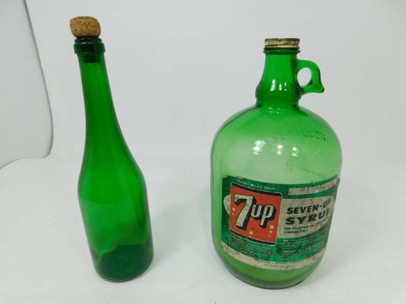 lot 78 image: Vintage Green One Gallon 7up Syrup Jug & Vintage Green Bottle With Cork