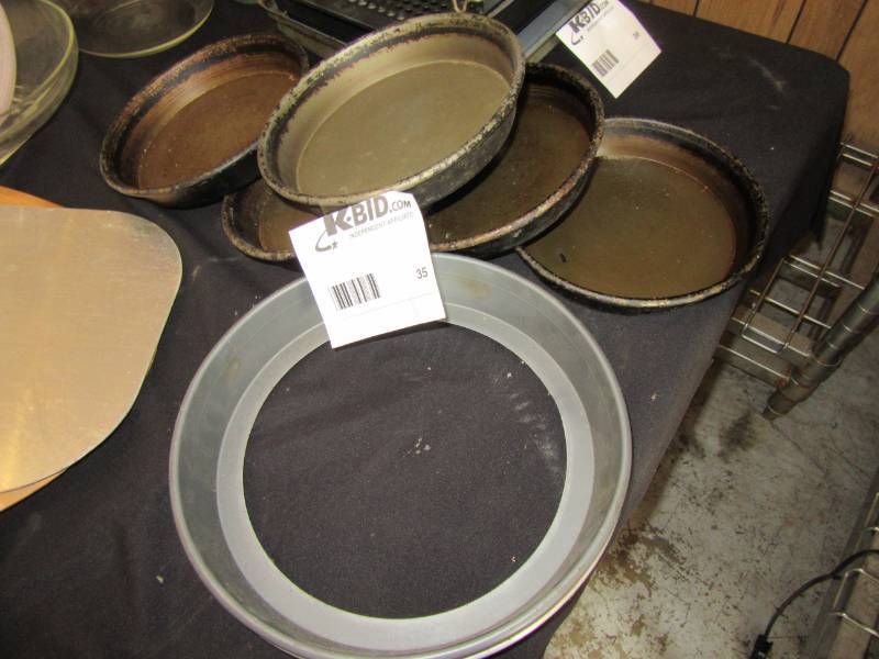 lot 35 image: 5 heavy metal, 8 in cakebaking pans.  Pie crust burn protector