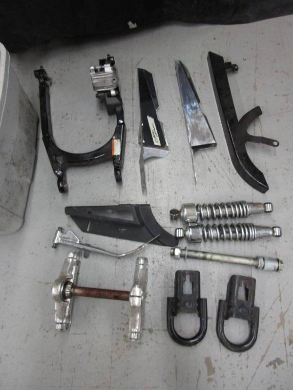 lot 130 image: 2009 Harley sportster fork covers, triple clamps, rear axle, 12 shocks  Fatboy swingarm