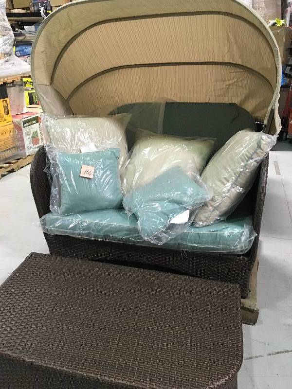 lot 106 image: Hampton Bay Deerfield All-Weather Wicker Patio Day Bed with Blue Cushions damaged bottom side and small tear on canopy see pictures Retails for $700 stock photo used to display item