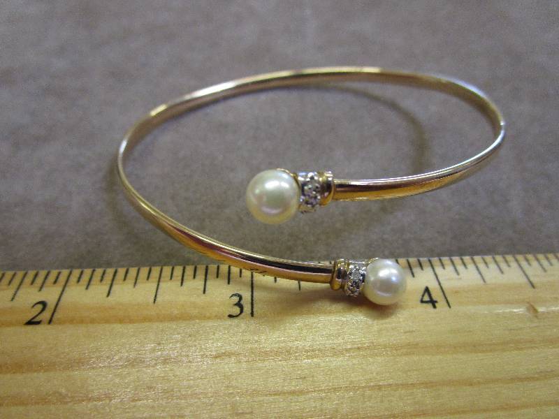 lot 111 image: 10K DIAMOND ACCENT  CULTURED PEARL BYPASS BANGLE 3.9 GRAMS