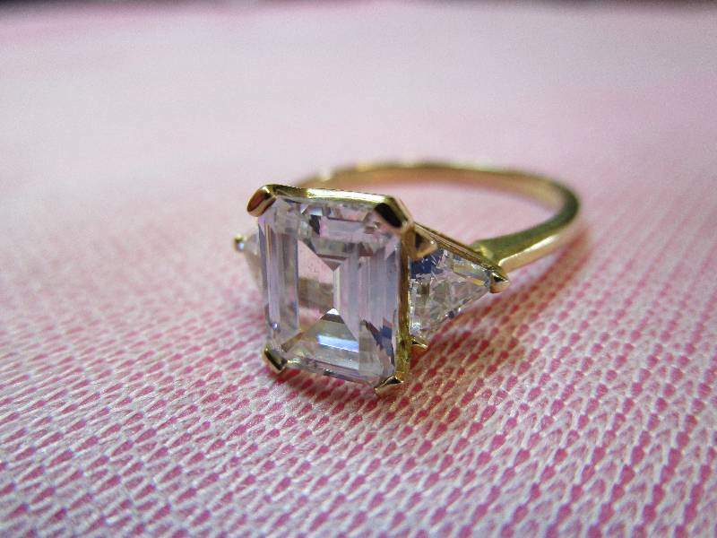 lot 140 image: 14K YELLOW GOLD SIZE 8 CZ DIAMONIQUE EMERALDTRILLION CUT RING, 3.2 GRAMS