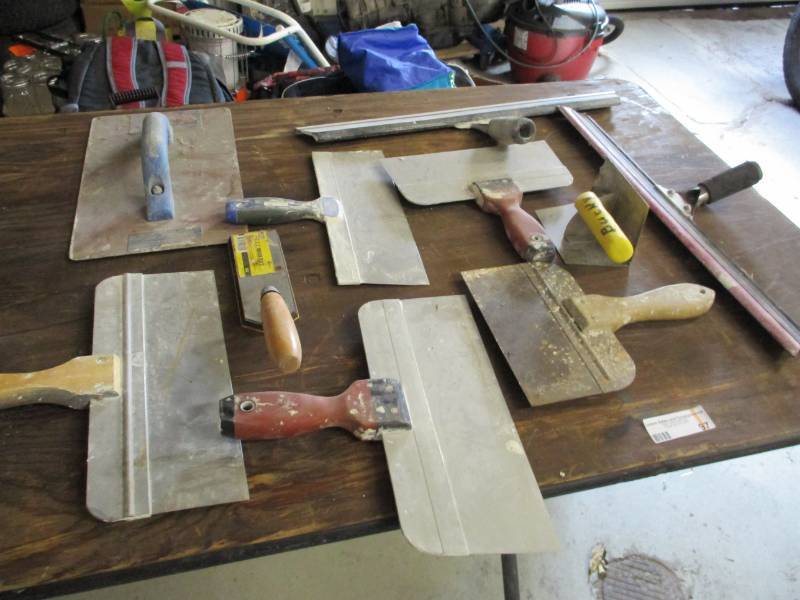 Lot of drywall knives and scrapers