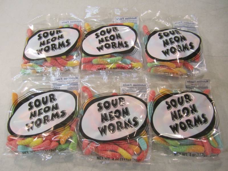 lot 216 image: 6 Bags of Sour Neon Worms Best by F...