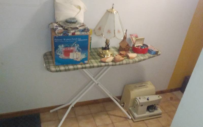 lot 86 image: Ironing Board, Kenmore Portable Sewing Machine & Sewing Notions, Shoe Stretchers, Lamp, Misc
