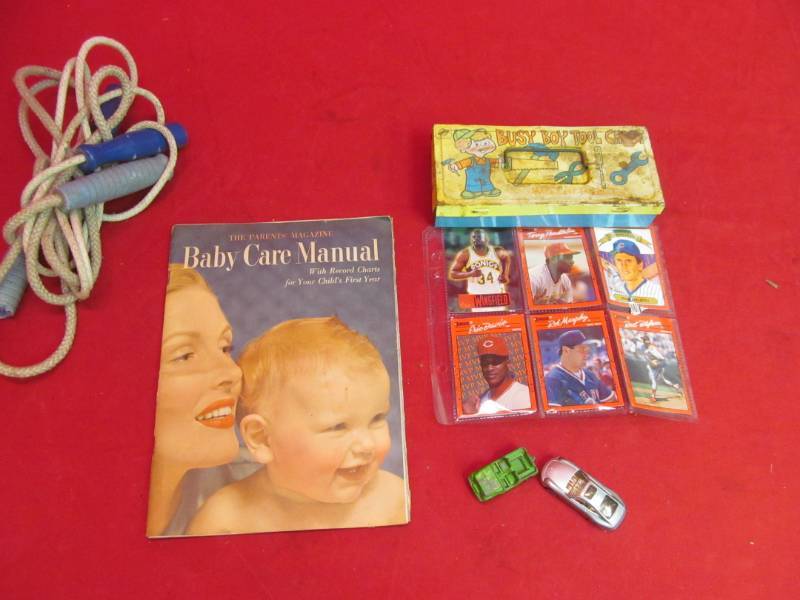 lot 22 image: Jump ropes, 1952 baby care manual, cars, busy boy toy box, baseball cards