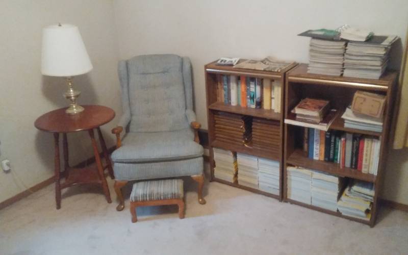 lot 24 image: 2-Book Shelves With Gun & Shooting Magazines 24x11x39, Chair, Footstool, Round Table 22 Inch Dia. X 26 Tall, Lamp With Shade