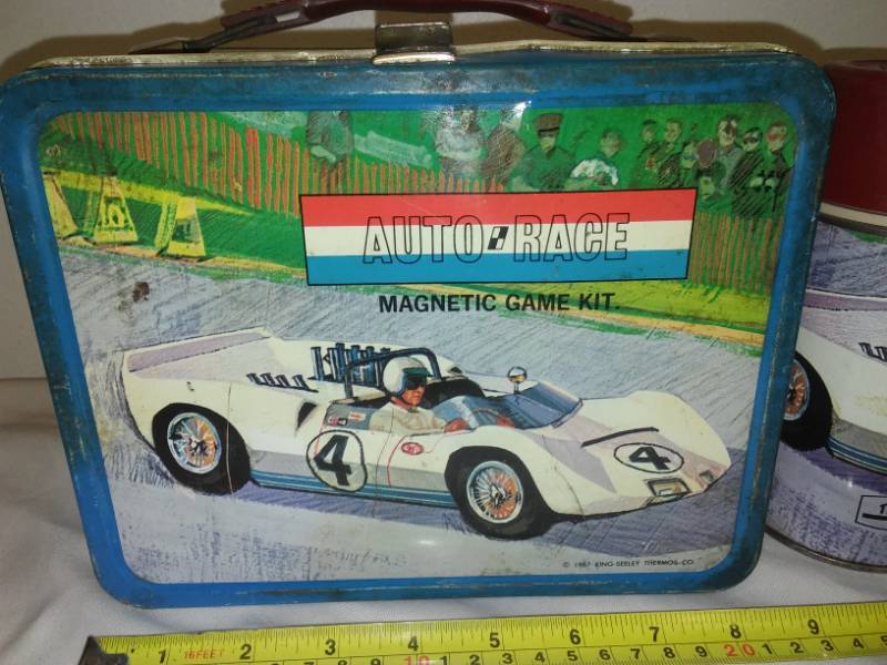 lot 36 image: Vintage lunchbox auto race with matching thermos.