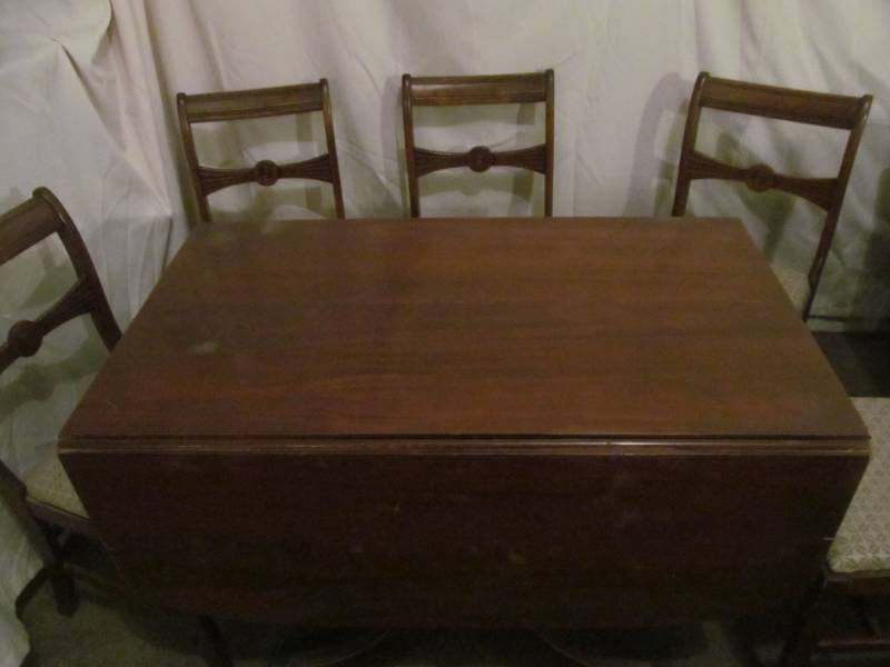 lot 50 image: Duncan Pyfe drop leaf table with 3 leaves, 6 chairs, table top pads