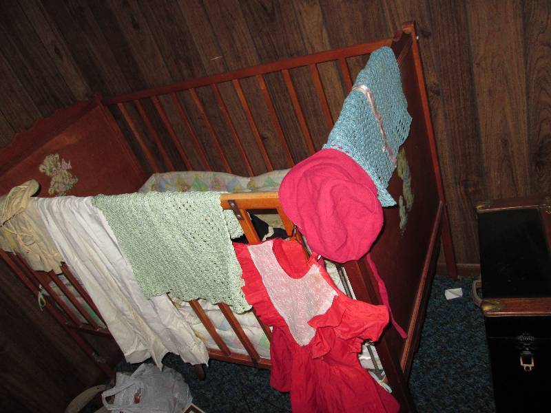 lot 130 image: Vintage crib with childs clothes an...