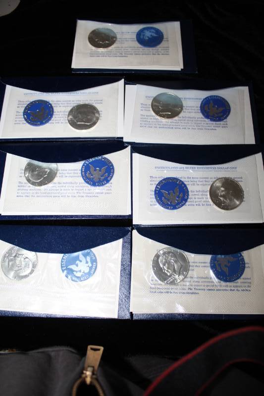 lot 301 image: Lot (7) 1971 to 1974 Eisenhower Uncirculated Silver dollar in Mint Packaging.