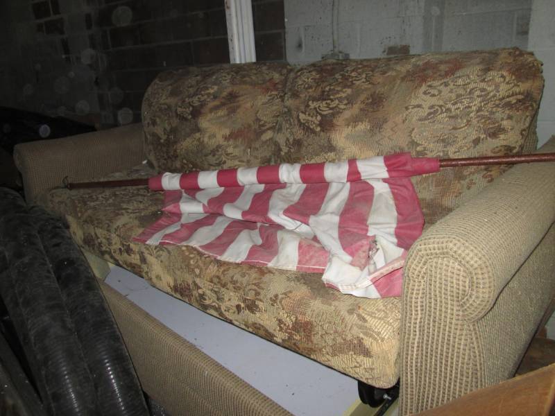 RV Couch and worn flag on pole...
