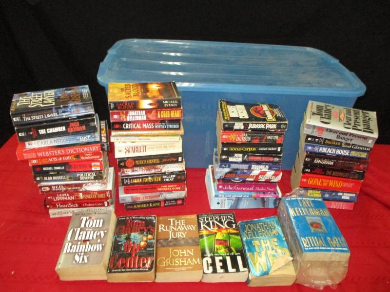 lot 26 image: Plastic container with novels from various authors, including Tom Clancy, James Patterson, Steven King