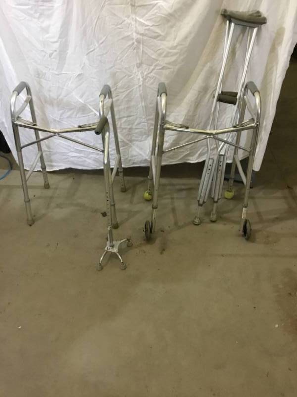 lot 28 image: Medical  Equipment  Two Walkers one with wheels and one pair of crutches, and a walker cane adjustable