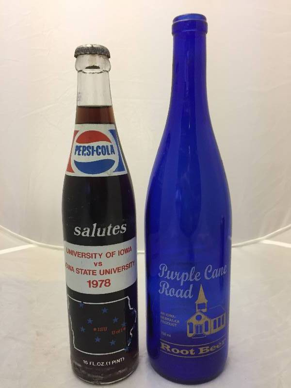 lot 481 image: Collectible Soda Pop Bottles - Pepsi 1978 U of Iowa Vs Iowa Stat & Purple Cane Road Root Beer