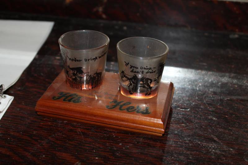 lot 42 image: Paul Bunyan His and Hers Shot Glasses Set with Wood Stand