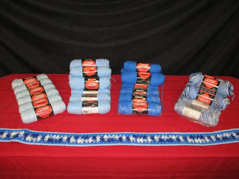 Several new rolls of blue yarn.  Knitted blue Scarf. Rubbermaid Tote