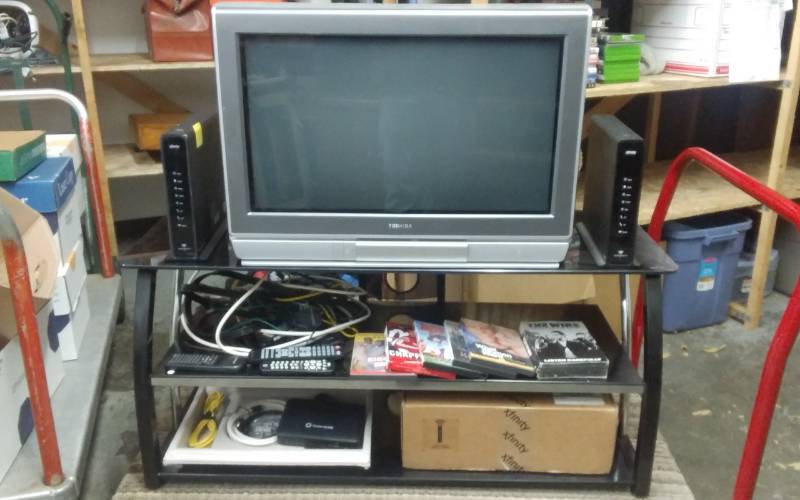lot 3 image: 3-Tier Entertainment Center With TV, X-Finity Box, DVDs. Router & Cables