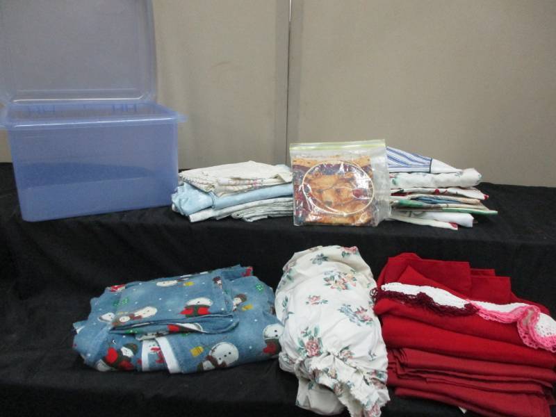 lot 102 image: 2 tubs of table cloths and linens