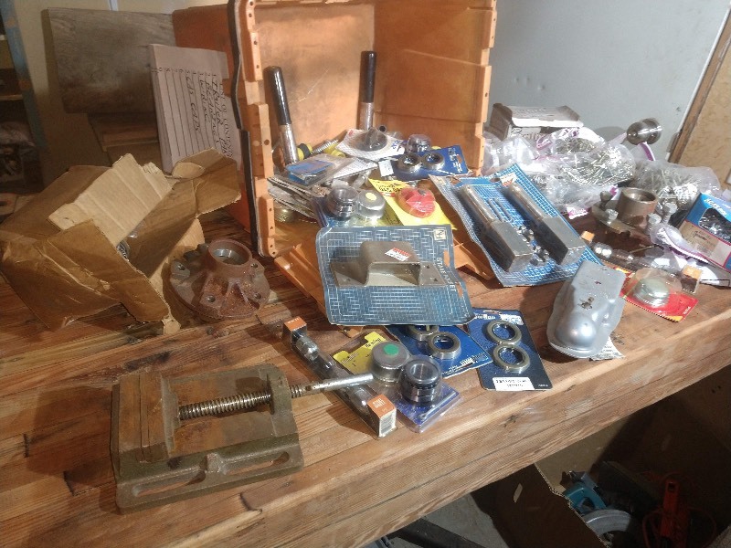 lot 27 image: Orange Industrial Tote, Flat Mouth Clamp, Valley 5105 1-78 Coupler, Trailer Parts, Bearings, Gas Caps, and Screws