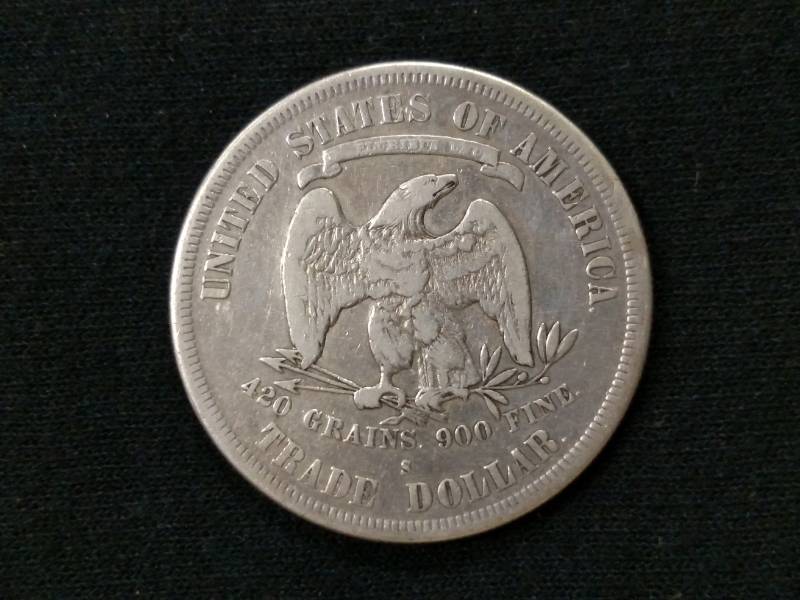 lot 7 image: 1877 S Trade Silver Dollar...