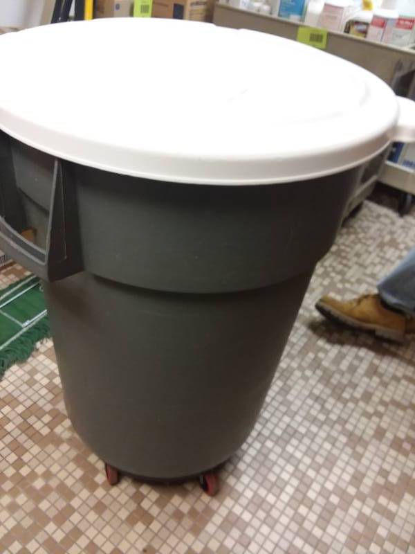 lot 452 image: 44 Gal. BRUTE Rubbermaid Covered trash can on roller dolly