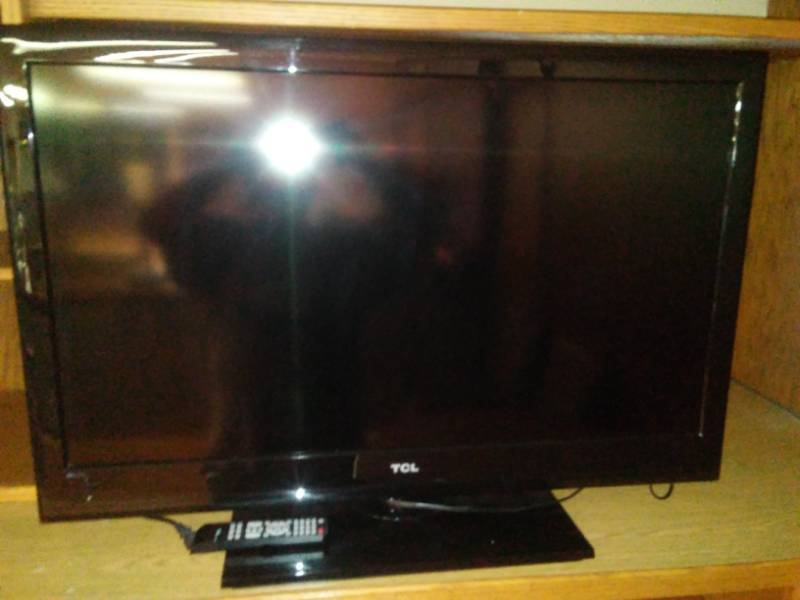 lot 214 image: TCL Flat screen TV with stand and remote. 