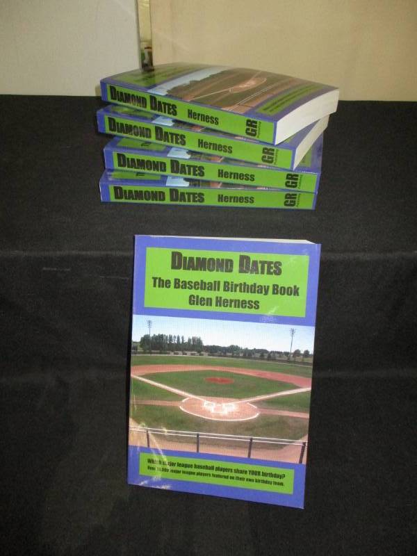 lot 98 image: 5 Count Diamond Date The Baseball Birthday Books Signed by Author Glen Herness. Field on front is the Fergus Falls Baseball Complex at Delagoon
