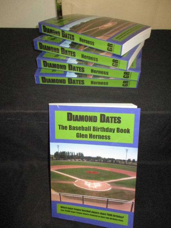 lot 102 image: 5 Count Diamond Date The Baseball Birthday Books Signed by Author Glen Herness. Field on front is the Fergus Falls Baseball Complex at Delagoon