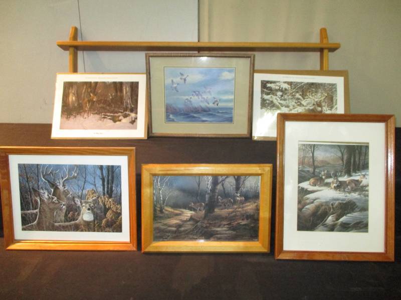 lot 195 image: Print Of the Year Minnesota Deer Hunters Association and other odd prints not labeled but signed, Terry Redlin, Jack Paluh Numbered 263 See Pictures and Shelf