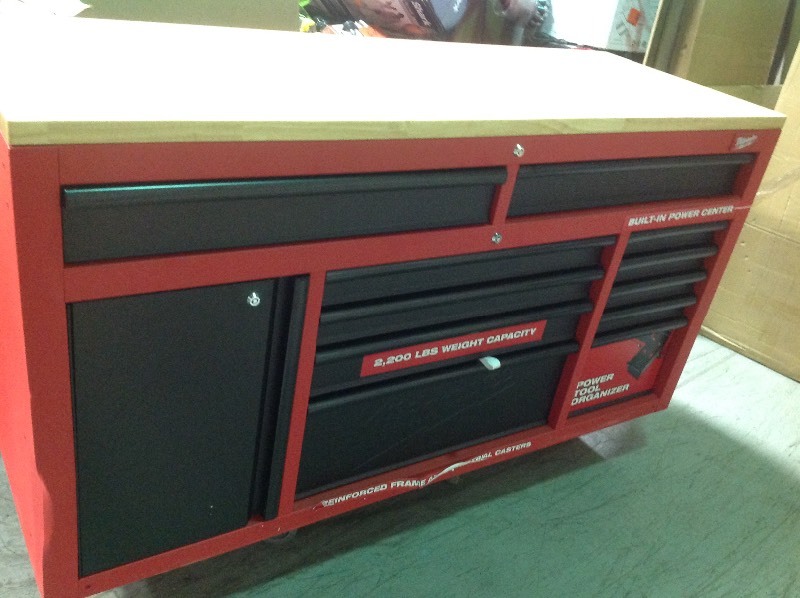 lot 110 image: Milwaukee  61 in. 11-Drawer1-Door 22 in. D Mobile Workbench with Sliding Pegboard Back Wall in RedBlack whit damage on side stock photo used to display the item