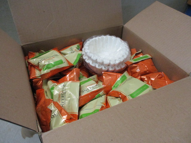lot 15 image: 1 Box of Ridgeline Coffee Roasters de-caffeinated coffee packs for percolated drip commercial or residential coffee machines. The box has 64 2oz packs with filters.