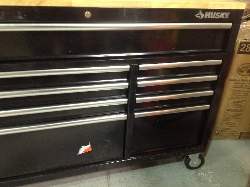 lot 104 image: Husky  52 in. x 24.5 in. D 9-Drawer Mobile Workbench in Black in good conditions whit damage on the side