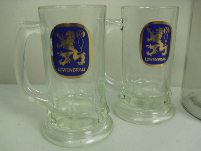 lot 139 image: Lot Of Vintage Heavy Bottom Lowenbrau Glass Mugs And Titos Vodka Embossed Glass Gallon Drink Dispenser