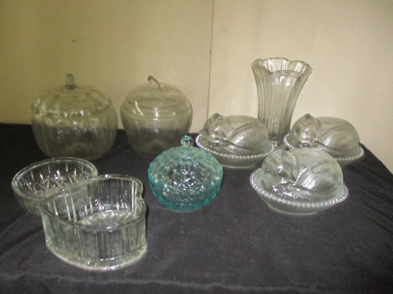 Cat on a nest, and apple container and oum pkin containers and greenish covered candy dish